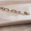 geel-en-witgouden-armband-met-ankerschakels