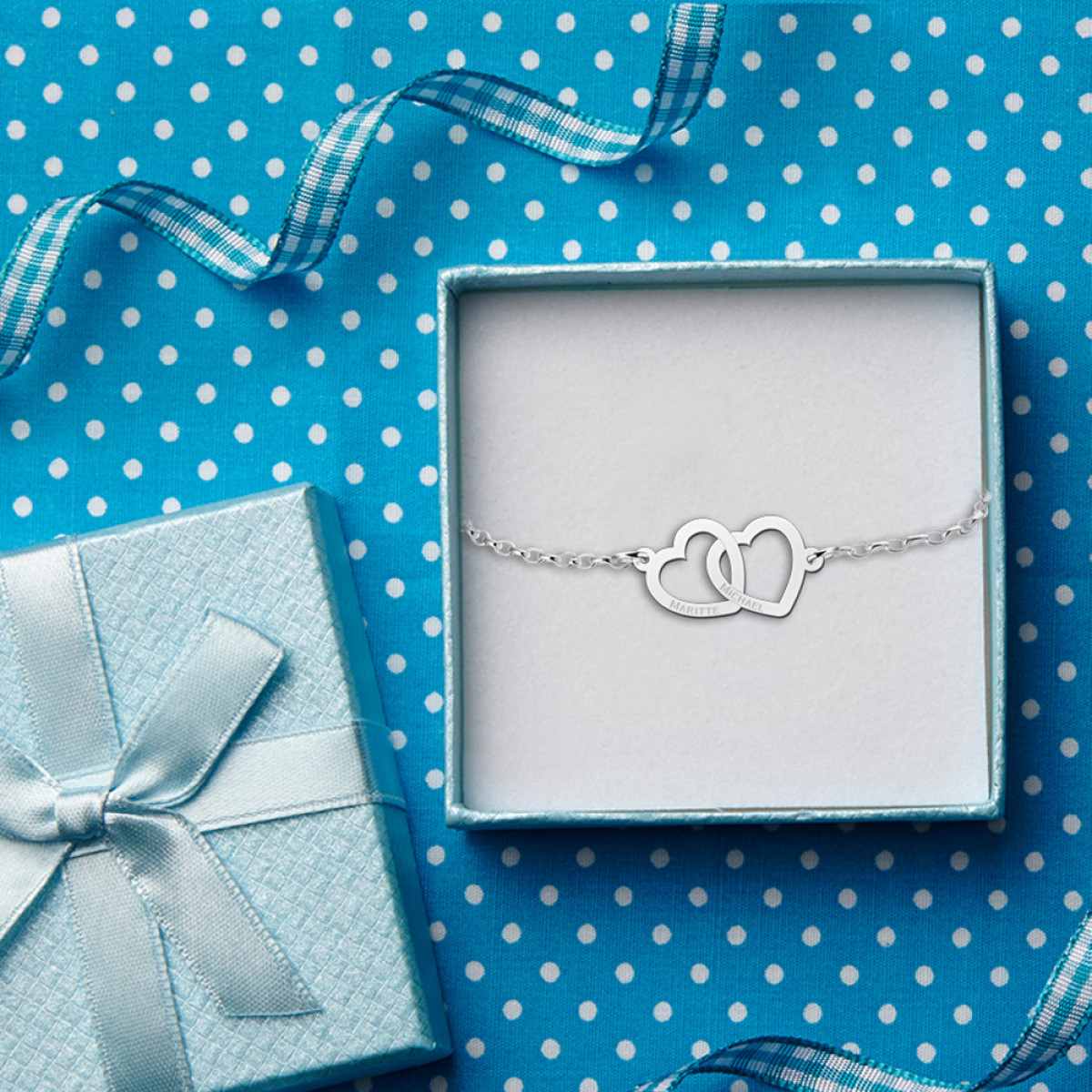 Names4ever zilveren armband met twee hartjes liggend en namen 